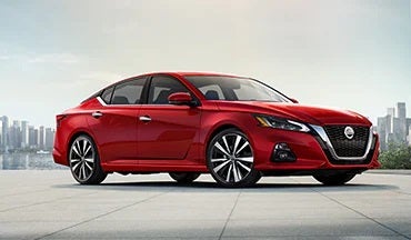 2023 Nissan Altima in red with city in background illustrating last year's 2022 model in JP Nissan in Blytheville AR
